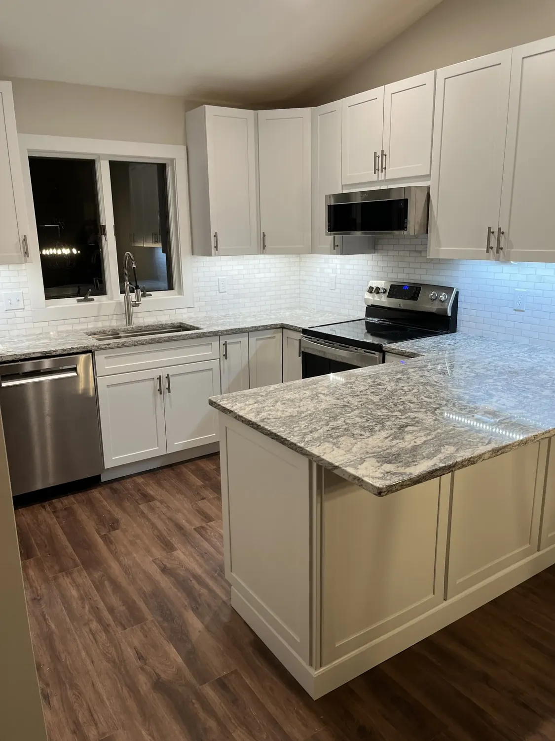 Kitchen remodel with white shaker cabinets and granite island